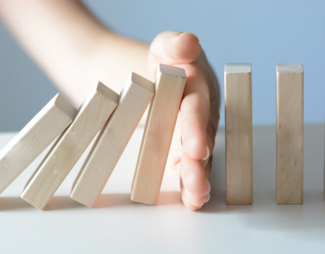Stopping the domino effect concept with a business solution and intervention Stopping the domino effect concept with a business solution and intervention